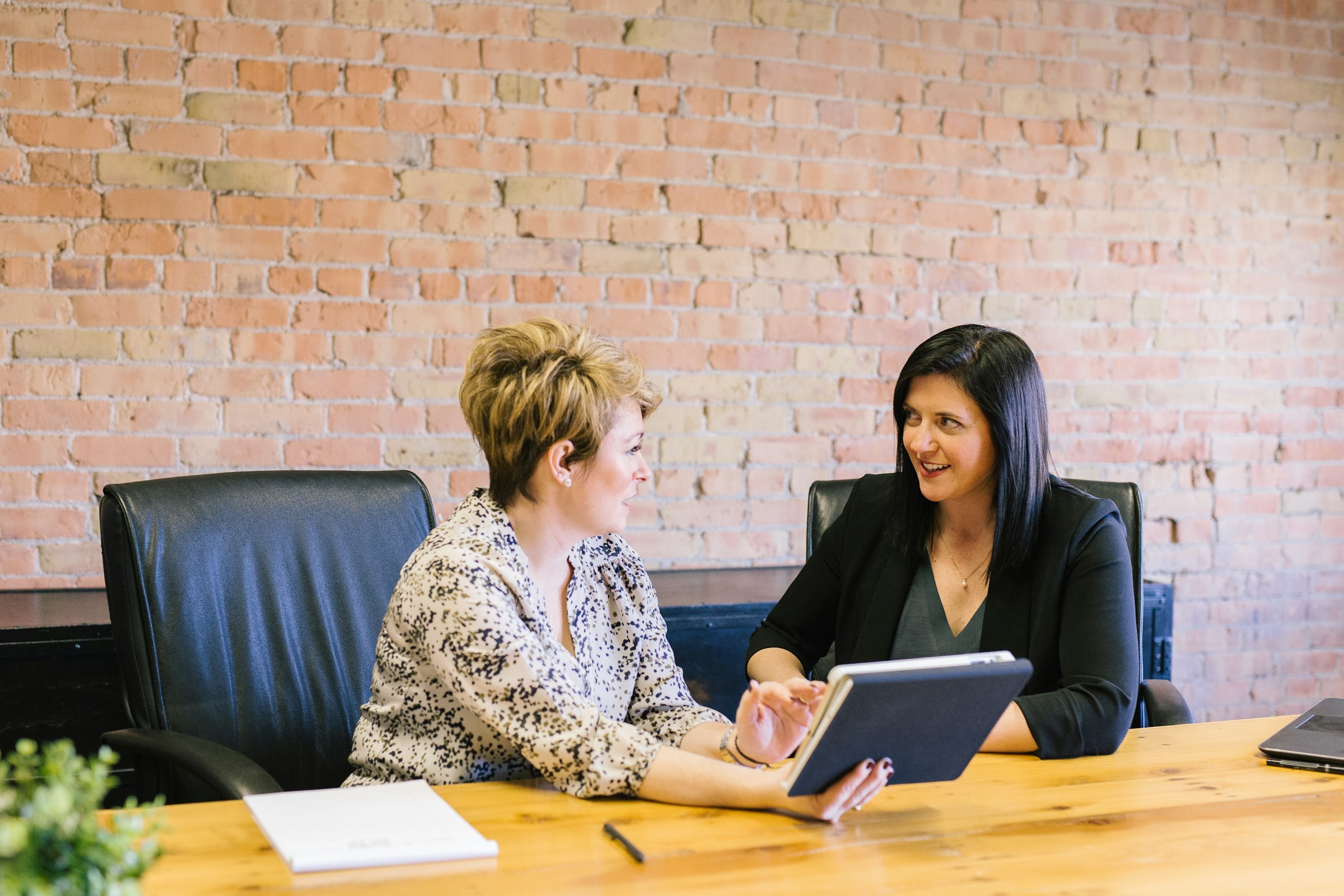 Two colleagues reviewing work together at a table